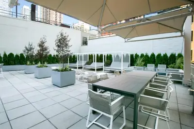 a patio with a table and chairs on a building at Blueground Hells Kitchen fitness center nr Hudson River Park NYC-2086 in New York