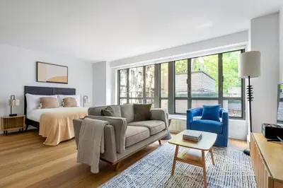 a living room with a couch and a bed at Blueground Yorkville pool nr Carl Schurz Park NYC-2093 in New York