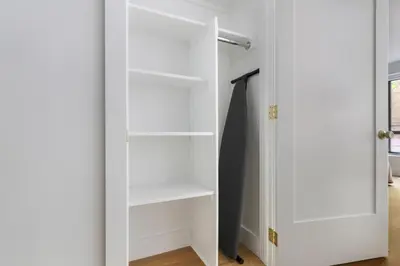 a closet with white shelves and a door at Blueground Yorkville pool nr Carl Schurz Park NYC-2093 in New York