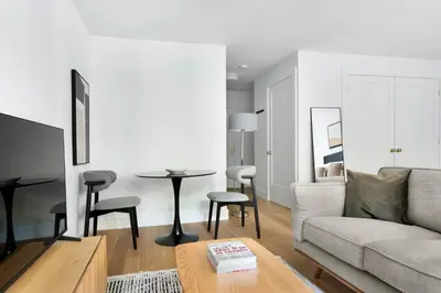 a living room with a couch and a table at Blueground Yorkville pool nr Carl Schurz Park NYC-2093 in New York