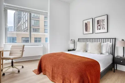 a bedroom with a bed and a chair and a window at Blueground Lincoln Square fitness center nr Riverside Park NYC-846 in New York