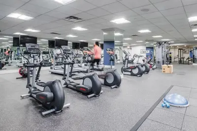 a gym with a bunch of treadmills and machines at Blueground Lincoln Square fitness center nr Riverside Park NYC-846 in New York