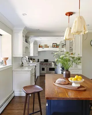 a kitchen with white cabinets and a table with a bowl of fruit at Argyll House by Boutique Litchfield Escape Villa in Harwinton
