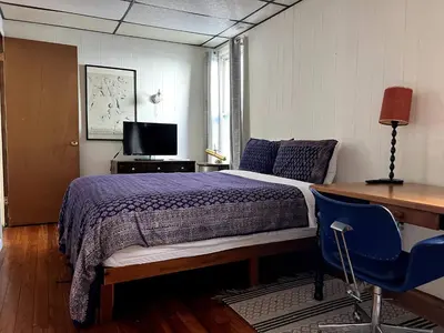 a bedroom with a bed and a desk and a computer at Sunny & spacious pied-à-terre by Union & Proctors! in Schenectady