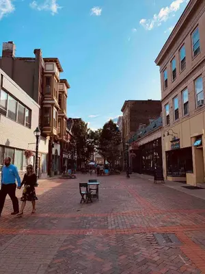 a man and a child walking down a city street at Sunny & spacious pied-à-terre by Union & Proctors! in Schenectady