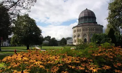 a building with a dome on top of a field of flowers at Sunny & spacious pied-à-terre by Union & Proctors! in Schenectady