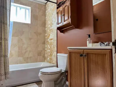 a bathroom with a toilet and a tub and a sink at Sunny & spacious pied-à-terre by Union & Proctors! in Schenectady