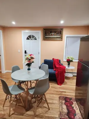 a living room with a table and chairs and a couch at Unique Home Rentals For Professionals in Baychester