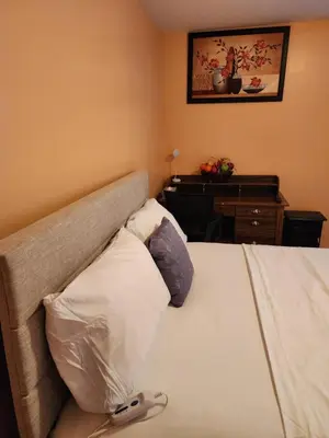 a bedroom with a bed and a dresser with a table at Unique Home Rentals For Professionals in Baychester