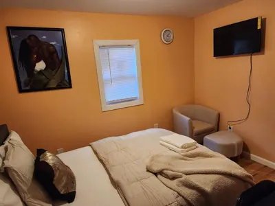 a bedroom with a bed and a tv and a chair at Unique Home Rentals For Professionals in Baychester