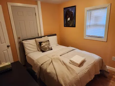 a bedroom with a bed with two pillows on it at Unique Home Rentals For Professionals in Baychester