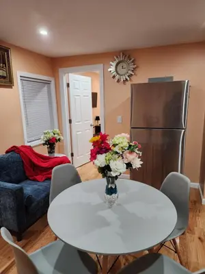 a living room with a white table and a refrigerator at Unique Home Rentals For Professionals in Baychester