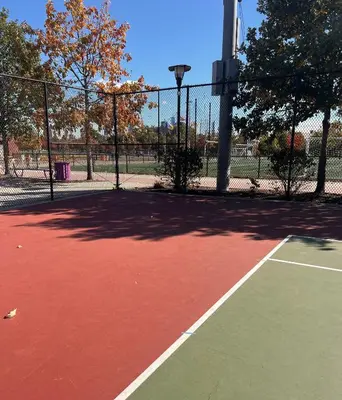 a tennis court with a fence on top of it at Studio Apartment with Garden Jersey City in Jersey City