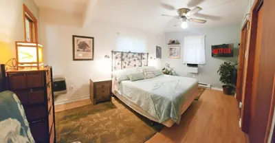 a bedroom with a bed and a ceiling fan at 1mi to Lake Wallenpaupack | Firepit | Pet Friendly in Greentown