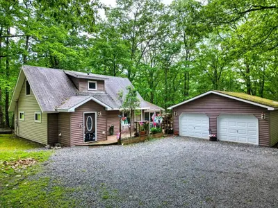 a house with a garage next to a driveway at 1mi to Lake Wallenpaupack | Firepit | Pet Friendly in Greentown