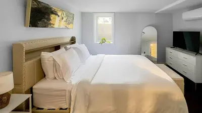a bedroom with a large white bed and a television at Modern Apartment Near Tweed -Yale -New Haven in New Haven