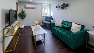 a living room with a green couch and a table at Modern Apartment Near Tweed -Yale -New Haven in New Haven