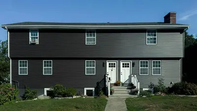 a large black house with a white door at Modern Apartment Near Tweed -Yale -New Haven in New Haven