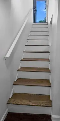 a stairway with white and wooden stairs with a door at Modern Apartment Near Tweed -Yale -New Haven in New Haven
