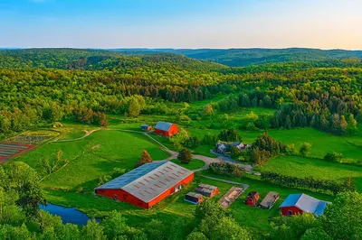 an aerial view of a farm with a barn at Forest Hideout Cottage Close to Camps and Ski Resorts in Pleasant Mount