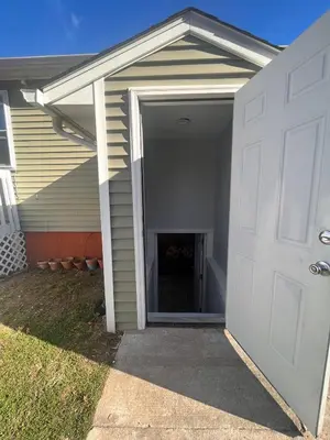 a garage with a white door next to a house at Spacious Family-friendly Apartment in New Haven