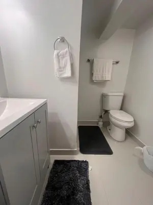 a bathroom with a toilet and a sink and towels at Spacious Family-friendly Apartment in New Haven