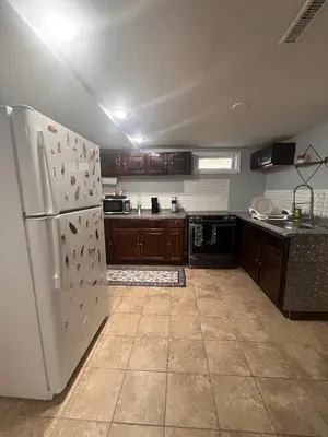 a kitchen with a white refrigerator and wooden cabinets at Spacious Family-friendly Apartment in New Haven