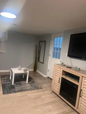 a living room with a flat screen tv and a table at Spacious Family-friendly Apartment in New Haven
