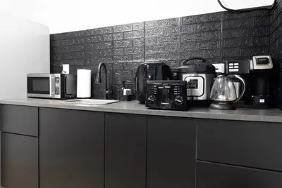 a kitchen counter with appliances on top of it at Bright 1-Bedroom Loft in Converted Garage with Private Entrance in New Rochelle