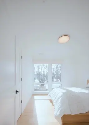 a white bedroom with a bed and a window at Modern living on the Quinnipiac River in New Haven