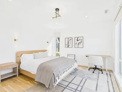a white bedroom with a bed and a desk at Modern living on the Quinnipiac River in New Haven