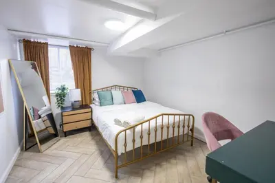 a bedroom with a bed and a table and a mirror at Retro 2 bedroom basement APT with free parking in New Rochelle