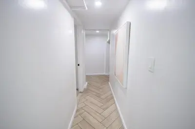 a hallway with white walls and a white door at Retro 2 bedroom basement APT with free parking in New Rochelle