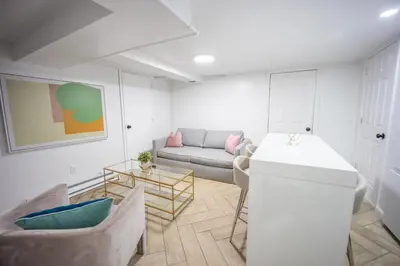 a living room with a couch and a table at Retro 2 bedroom basement APT with free parking in New Rochelle