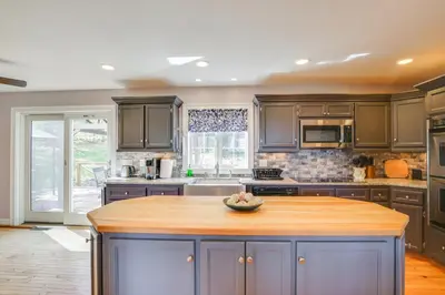 a kitchen with gray cabinets and a wooden island at New Milford Home 29 Mi to Lime Rock Park! in New Milford