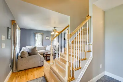 a living room with a staircase and a couch at New Milford Home 29 Mi to Lime Rock Park! in New Milford
