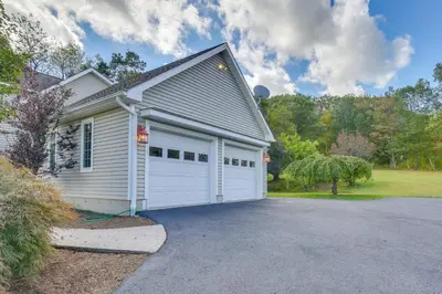a house with a white garage with a driveway at New Milford Home 29 Mi to Lime Rock Park! in New Milford