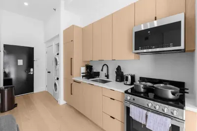 a kitchen with a stove and a sink and a microwave at 19-4G 2BR 2Baths Luxury Apt East Village in New York