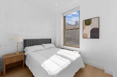 a white bedroom with a bed and a window at 19-4G 2BR 2Baths Luxury Apt East Village in New York