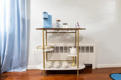 a gold and white shelf with cups on it at Bright 3bed basement with backyard & free parking in Yonkers