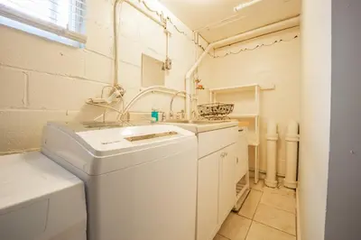 a white laundry room with a sink and a washing machine at Bright 3bed basement with backyard & free parking in Yonkers