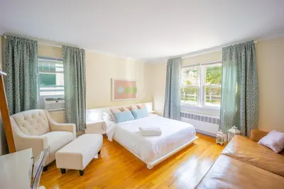 a bedroom with a bed and a chair and a couch at 3bedroom APT with balcony & free street parking in Yonkers