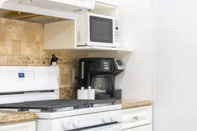 a kitchen with a microwave and a stove top oven at 3bedroom APT with balcony & free street parking in Yonkers