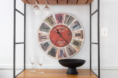 a large clock on a wall with two wine glasses at 3bedroom APT with balcony & free street parking in Yonkers