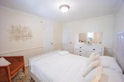 a white bedroom with a bed and a sink at 3bedroom APT with balcony & free street parking in Yonkers