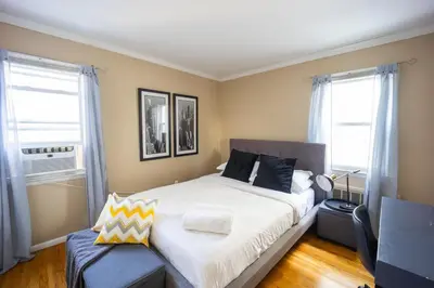 a bedroom with a large bed and two windows at 3bedroom APT with balcony & free street parking in Yonkers
