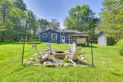a house with a fire pit in the yard at Hot Tub and Game Room Wooded Poconos Retreat in Tobyhanna