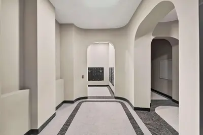 a hallway with white walls and a hallway with a rug at Freeman II by Rove 1BR Condo with Shared Amenities in New York