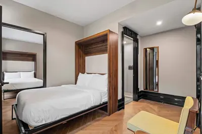 a bedroom with a large bed and a mirror at Freeman 201 by Rove Travel - 2BR Condo with Shared Amenities in New York