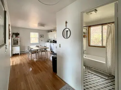 a kitchen and living room with a table and a tub at Fireplace Catskill Views Overlook Lake Cabin in Parksville